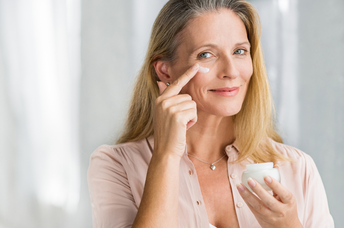Image of woman applying skin cream to face